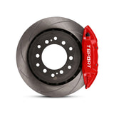 Close-up of a red TTSPORT Toyota Tundra & Sequoia 4-piston forged brake caliper for the rear wheel and a slotted 2-piece rotor.